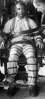 A (black) man being strapped into the electric chair at Sing Sing prison in the early 20th century.